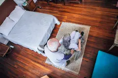 Senior man pushing his wife in wheelchair at home