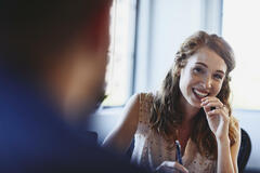 Womale smiling at a colleague holding a pen.Randstad Human Forward