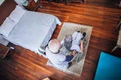 Senior man pushing his wife in wheelchair at home