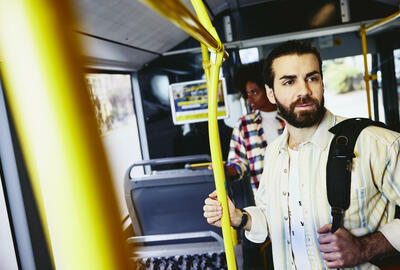 male standing in bus.
