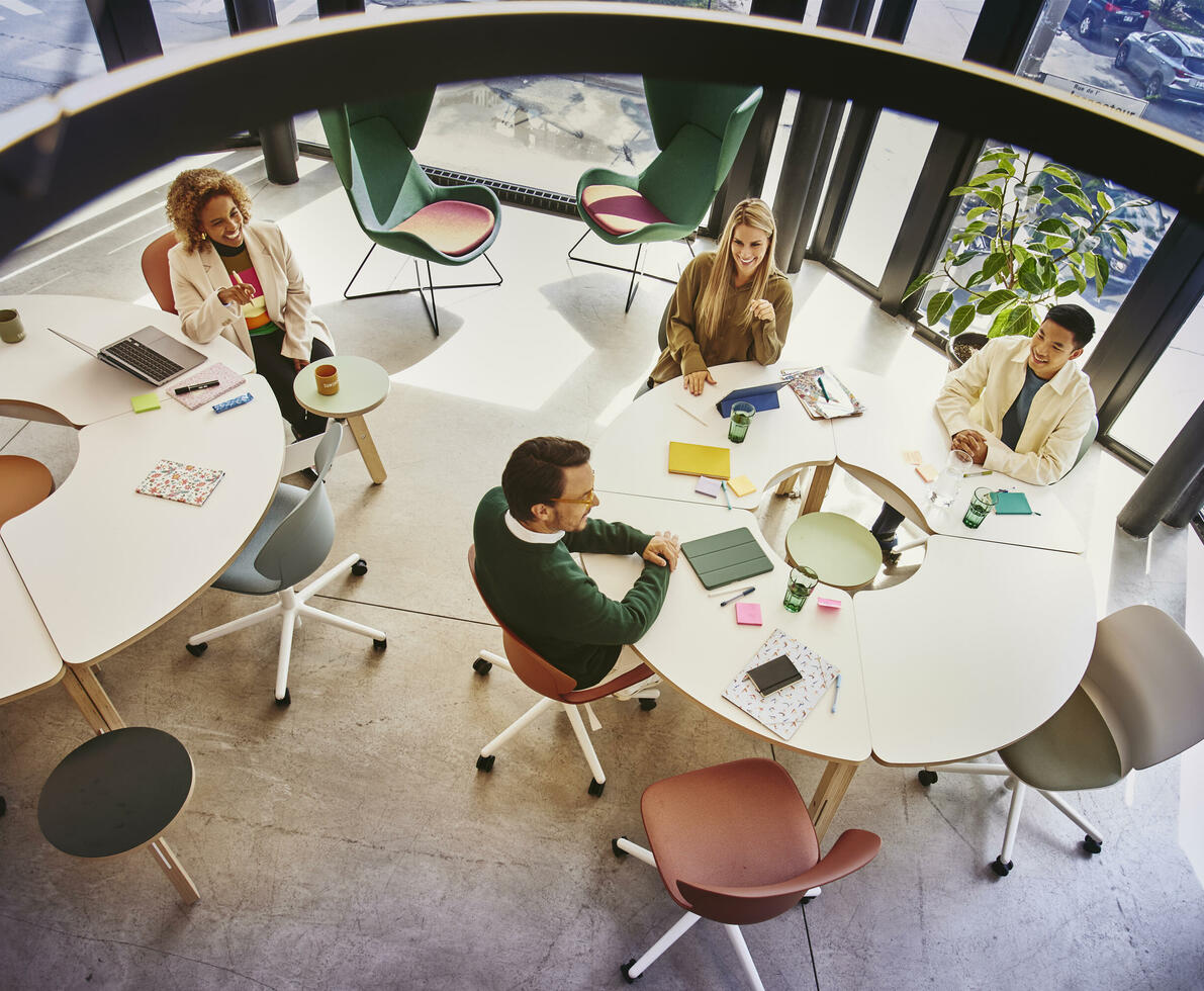 Bird view of people sitting at a round table and having a meeting