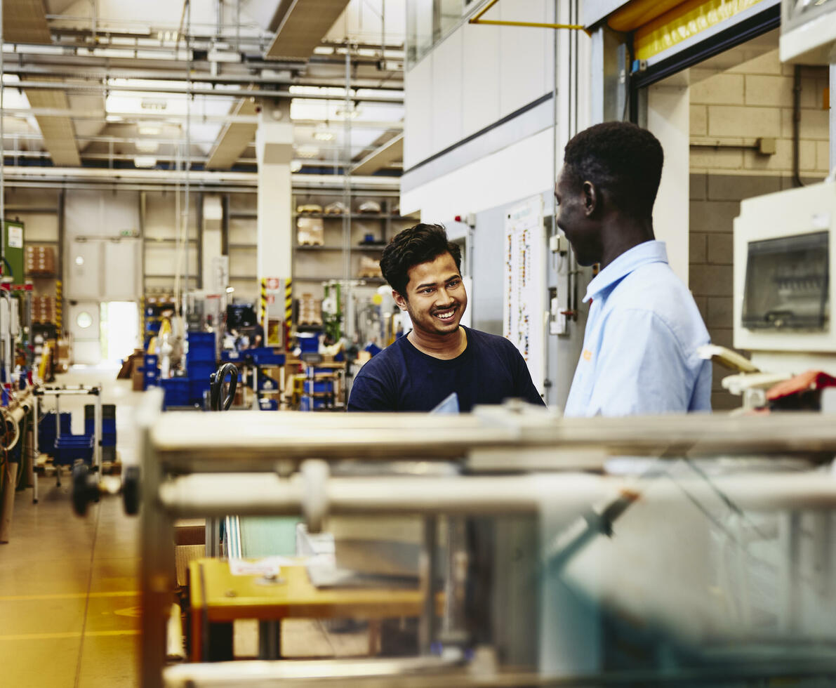 Two colleagues working together on a maleufacturing site.
