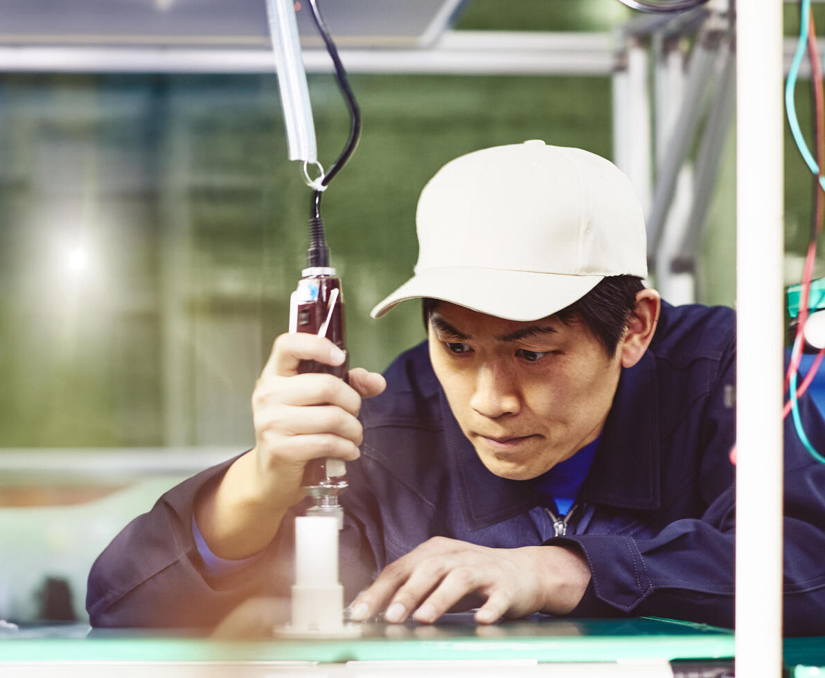 male wearing a white hat working with tools on a production site
