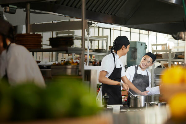 2 asian colleagues working in a restaurant kitchen