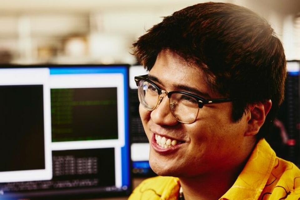 man smiling behind his computer