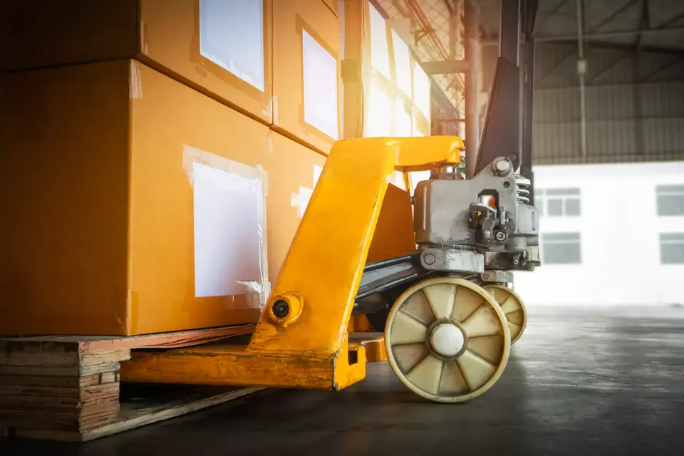 Hand pallet truck with packaging boxes stacked on pallets.