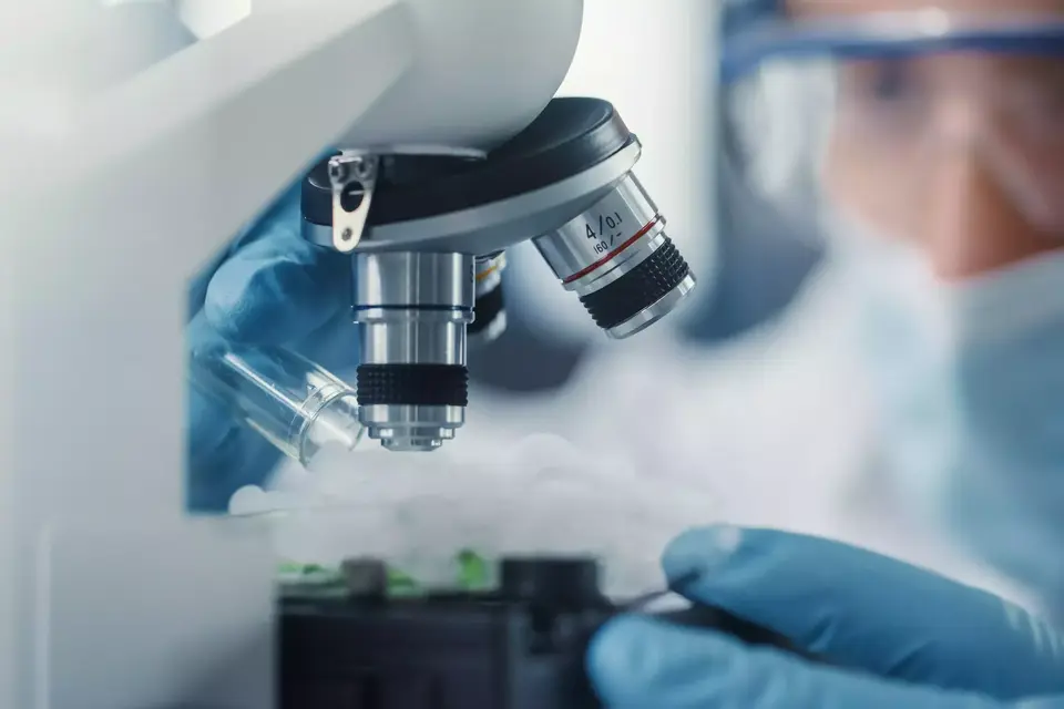Close up photo of person looking at a microscope.